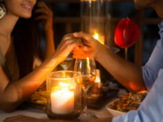 Explore Love and Singleness with Local Valentine’s Day Events in 2023 Romantic couple holding hands together over candlelight during romantic dinner