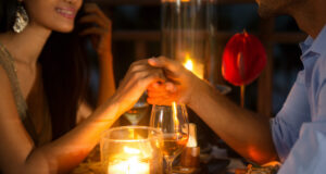 Explore Love and Singleness with Local Valentine’s Day Events in 2023 Romantic couple holding hands together over candlelight during romantic dinner